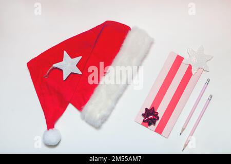 santa hat and letter with pencil. New Year or Christmas wish list. Holiday banner from above Stock Photo