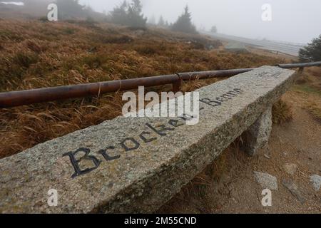 Schierke, Germany. 26th Dec, 2022. A bench in honor of the record hiker Brocken-Benno, who died on 23.12.2022, stands on the Brocken summit. Drizzle and fog currently dominate the weather on the Brocken. Only a few hikers are on the summit. Credit: Matthias Bein/dpa/Alamy Live News Stock Photo