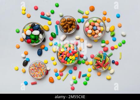 different colored round candy in bowl and jars. Top view of large variety sweets and candies with copy space. Stock Photo