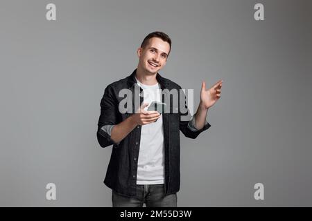 man using cell phone isolated on gray background. Stock Photo