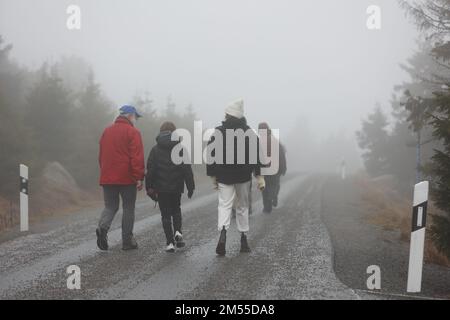 Schierke, Germany. 26th Dec, 2022. Hikers are in the fog on the Brocken road. Drizzle and fog are currently dominating the weather on the Brocken. Only a few hikers are on the way to the summit. Credit: Matthias Bein/dpa/Alamy Live News Stock Photo