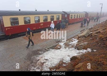 Schierke, Germany. 26th Dec, 2022. A train of the Harzer Schmalspurbahn HSB arrives at the Brocken station.Due to the holidays there are limited train services at the HSB. Drizzle and fog are currently dominating the weather on the Brocken. Only a few hikers are on the summit. Credit: Matthias Bein/dpa/Alamy Live News Stock Photo