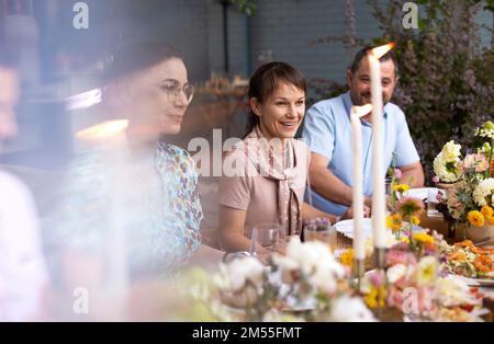 Many people saying cheers and showing their champagne glasses full of sparkling wine to each other whilst enjoying an outdoor wedding party on a backy Stock Photo