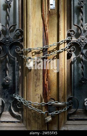 Old wooden door of an abandoned house is locked. Chain on the vintage door of a closed mansion. High quality photo Stock Photo