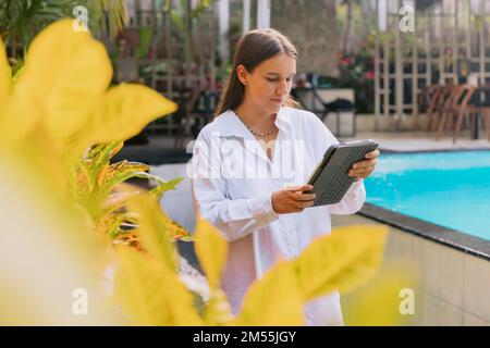 Attractive young woman designer using her laptop digital tablet in outdoor Stock Photo