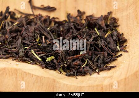Thyme black tea dried leaves in a wooden bowl. Medicinal herb drink Stock Photo