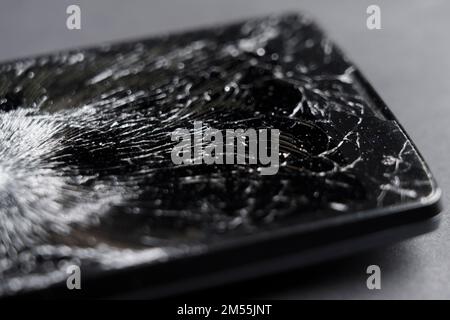 Black smashed crushed mobile phone with broken cracked display. Macro Stock Photo