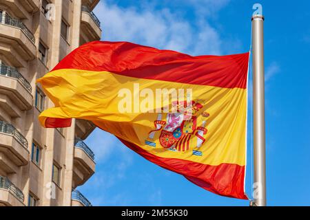 Closeup of a Spanish flag blowing in the wind against a clear blue sky in Spain Square (Plaza de Espana), Madrid downtown, Spain, southern Europe. Stock Photo
