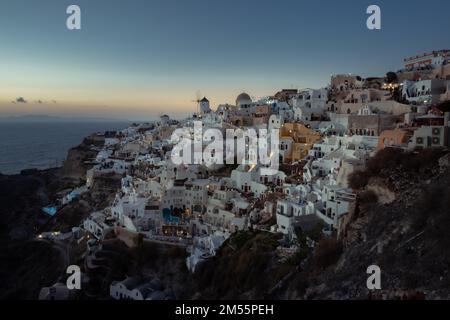 An aerial view of Santorini island surrounded by buildings during sunset Stock Photo