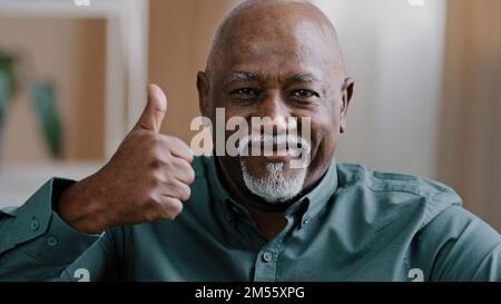 Portrait of happy old male ethnic elderly African American man senior showing thumb up positive grandfather looking at camera showing hand gesture of Stock Photo