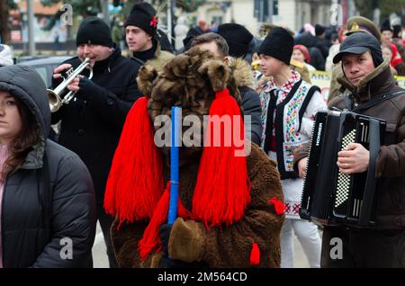 People wearing colorful costumes and masks perform during a traditional Christmas festival in northern Romania. Stock Photo