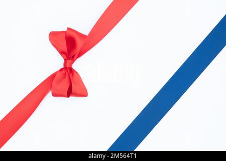 Satin ribbon bows for gift pack in red and blue colors, isolated on white background. Background with ribbon knot on white background. Stock Photo