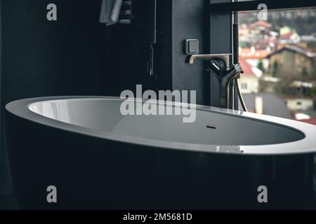 Bathtub in the interior of the bathroom with a window. Stock Photo