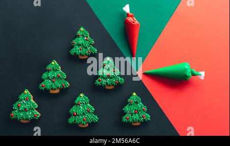 Christmas tree shaped gingerbread cookies covered with icing, flat lay. Stock Photo
