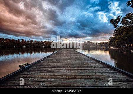 A beautiful view of a pathway over the lake during sunset Stock Photo
