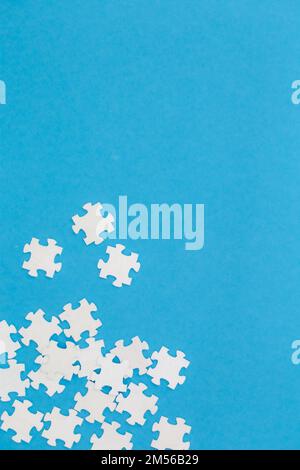 White puzzles on a blue background, flat lay. Stock Photo