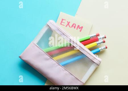 exam word in a sticky note and pencils on color background  Stock Photo