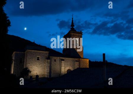 A waxing crescent moon rises over Iglesia de San Nicolás de Bari in Molinaseca, León, Spain. The village lies along the Camino Frances, a typical rout Stock Photo