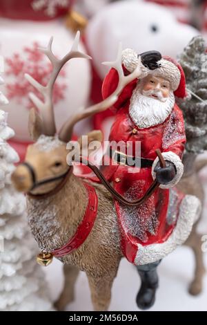 Christmas decoration, Santa Claus riding on a reindeer. Christmas eve snowy night scene with santa claus riding on reindeer. Nobody, selective focus Stock Photo