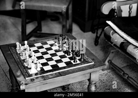 Old chess game on vintage table in black and white Stock Photo