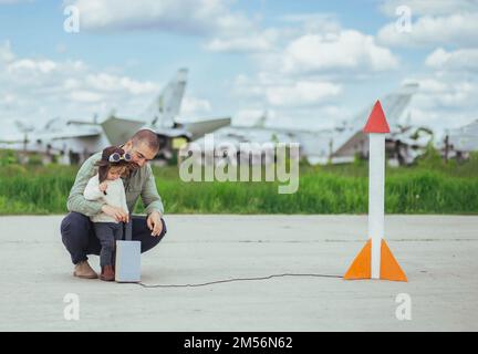 Father and daughter launch a rocket at the aerodrome Stock Photo