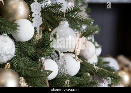 Christmas tree, New Year home decorations, golden ans silver balls, festive tree decorated with garland, baubles, traditional celebration. Copy space Stock Photo