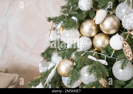 Christmas tree, New Year home decorations, golden ans silver balls, festive tree decorated with garland, baubles, traditional celebration. Copy space Stock Photo