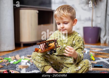 Happy child boy plays with toy airplane and dreams of becoming a pilot Stock Photo