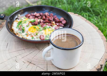 breakfast in the forest: scrambled eggs with sausage and coffee  Stock Photo