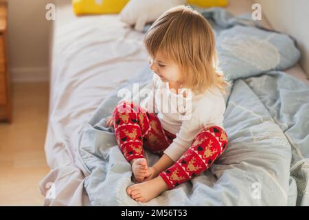 charming beautiful baby in festive leggings on the bed Stock Photo