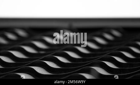 Black metal roof tiling with wavy shape pattern, close up black and white photo of modern countryside house roof Stock Photo