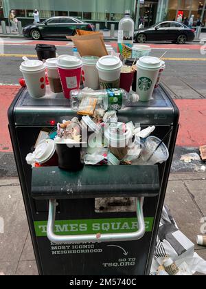 Overflowing garbage compactor mostly filled with one use coffee cups at Bryant Park in midtown Manhattan during the crowded Christmas  holiday season. Stock Photo