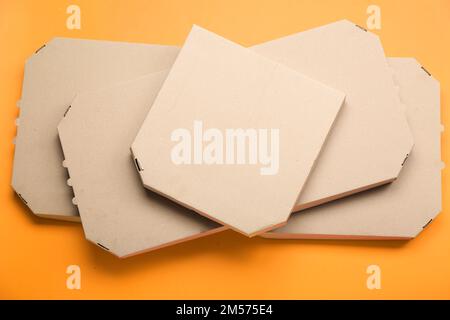 Stack of cardboard pizza boxes on color background Stock Photo