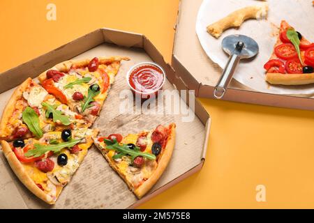 Cardboard boxes with tasty pizza on color background, closeup Stock Photo