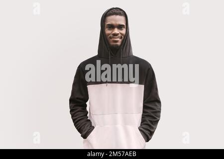 Studio portrait of smiling black man in hoodie isolated on white backdrop. Handsome student in casual clothes posing confident Stock Photo