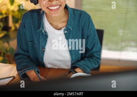 Close up of smiling woman freelancer is working on computer in home office Stock Photo