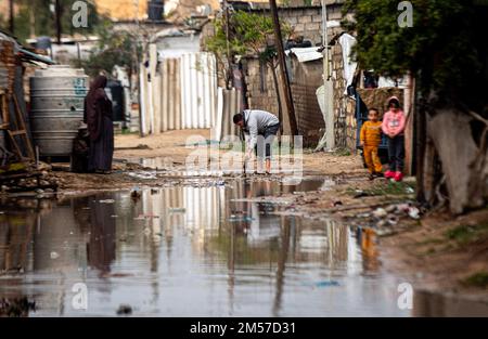 Gaza, Palestine. 26th Dec, 2022. Palestinians stand on a street flooded with rainwater in a poor neighborhood on the outskirts of Khan Yunis camp, in the southern Gaza Strip. Credit: SOPA Images Limited/Alamy Live News Stock Photo