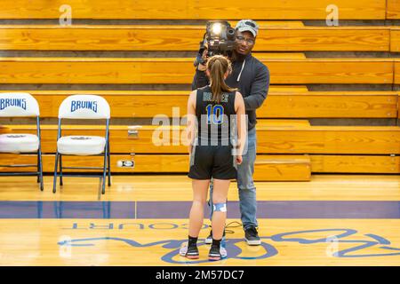 A Blackhawk Christian High School player is interviewed by a television news cameraman after a varsity girls' basketball game in Goshen, Indiana, USA. Stock Photo