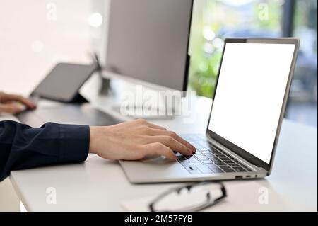 cropped and side view, Professional male programmer or web developer using laptop computer, working at his desk. Stock Photo