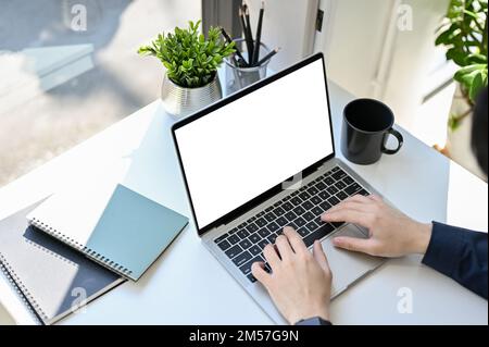 Top view, Professional businessman or male office worker using laptop computer, typing on notebook keyboard at his office desk. laptop white screen mo Stock Photo