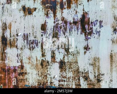 Close up to colored peeling paint texture on rusty metal surface. The old steel wall, painted and putty, peels off and collapses. Grunge background te Stock Photo