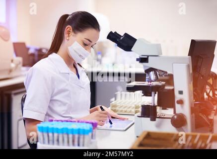 The latest technological tools for a lab technician. a young scientist using a digital tablet while working in a laboratory. Stock Photo