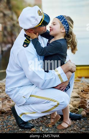 Every father is his daughters first love. a father in a navy uniform bonding with his little girl on the dock. Stock Photo