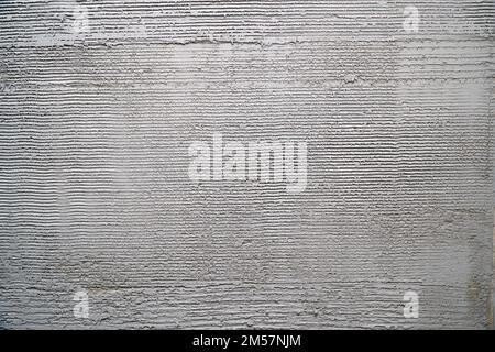 Gray decorative plaster on the wall with pressed horizontal stripes. Plaster background Stock Photo