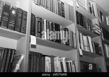 Chapaevsk, Samara region, Russia - December 24, 2020: Books on a shelf in the library. Black and white photo Stock Photo