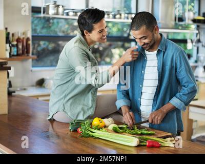 Youre the cutest chef Ive ever seen. a smiling young couple preparing a meal together in their kitchen. Stock Photo