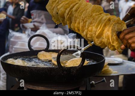 poori or puri or luchi being fried in hot steaming oil.traditional indian breakfast snack. Stock Photo