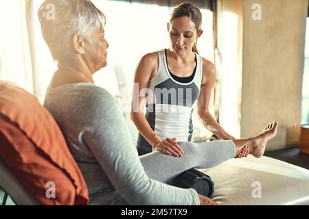Putting right whats gone wrong. a senior woman being treated by a physiotherapist. Stock Photo