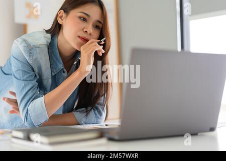 Construction design concept, Female architect use calculator and looks house plan project on laptop. Stock Photo