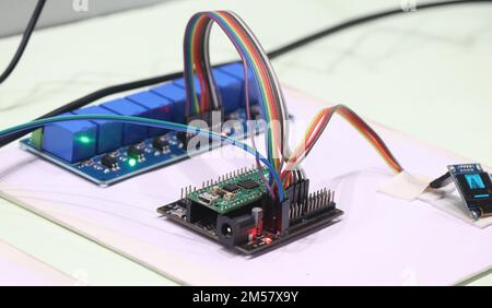 Relay module with optocoupler connected to a programmable microcontroller board to work on some prototyping projects Stock Photo
